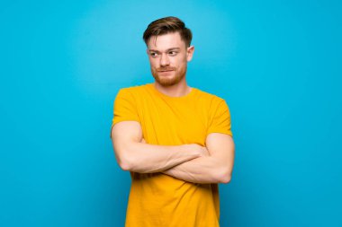 Mavi duvar portresi üzerinde Redhead adam