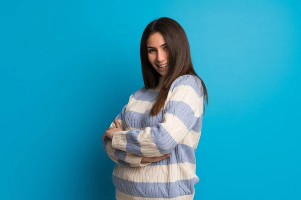 Jonge vrouw over blauwe muur — Stockfoto