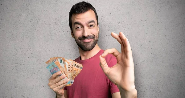 Adam dokulu duvar üzerinde parmakları ile ok işareti gösteren çok para alarak