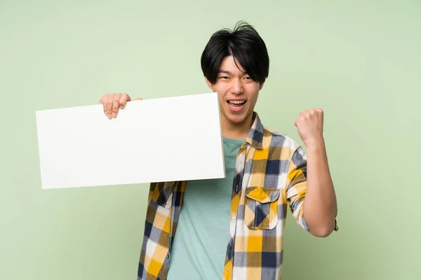 Asian Man Isolated Green Wall Holding Empty White Placard Insert — Stock Photo, Image