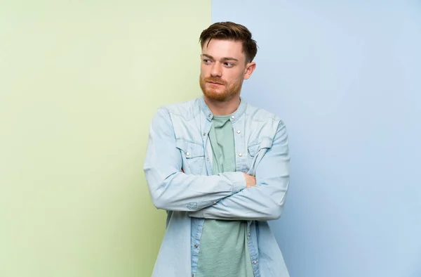 Redhead man over colorful background portrait