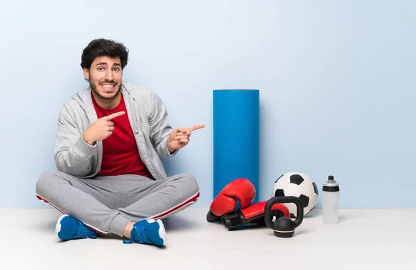 Esporte Homem Sentado Chão Assustado Apontando Para Lado — Fotografia de Stock