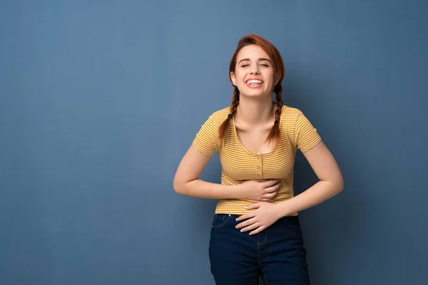 Jonge Roodharige Vrouw Blauwe Achtergrond Glimlachen Veel Terwijl Het Zetten — Stockfoto