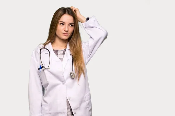 Young Doctor Woman Having Doubts While Scratching Head Isolated Grey — 스톡 사진