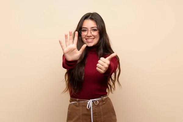 Teenager girl with glasses counting six with fingers