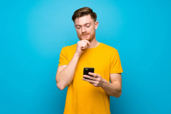 Redhead Man Blue Wall Thinking Sending Message — Stock Photo, Image