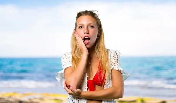 Blonde Girl Summer Vacation Surprised Shocked While Looking Right Beach — Stock Photo, Image