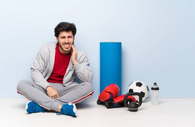 Spor adam diş ağrısı ile katta oturan