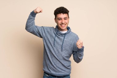 Genç adam tecrit edilmiş duvarda zaferi kutluyor.