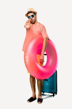 Onun yaz tatilinde şapka ve güneş gözlüğü ile Man Tam vücut elini izole arka plan üzerinde yanlış düşünen bir durum inkar ile stop jest yapma