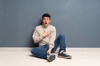 Yerde oturan genç adam sağ bakarken şaşırttı ve şok