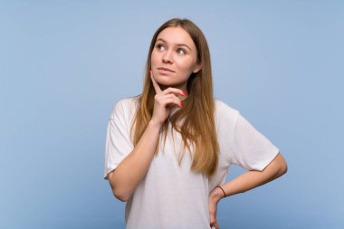 Mavi duvarın ardındaki genç kadın yukarı bakarken bir fikir düşünüyor.