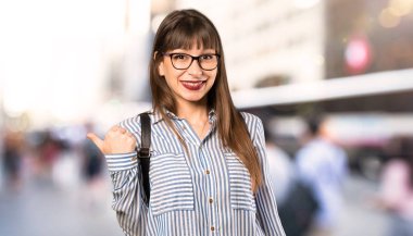 Açık havada bir ürün sunmak için yan işaret gözlük ile kadın