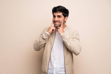 Mutlu ve keyifli bir ifadeyle gülümseyen izole duvarın üzerinden genç adam