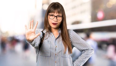 Gözlük ile kadın açık havada parmaklarla beş sayma