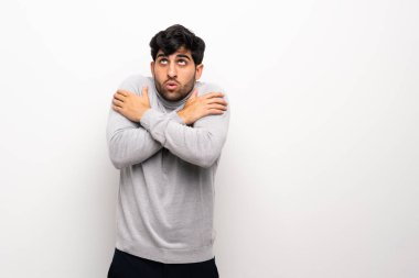 İzole edilmiş beyaz duvarın üzerindeki genç adam donuyor