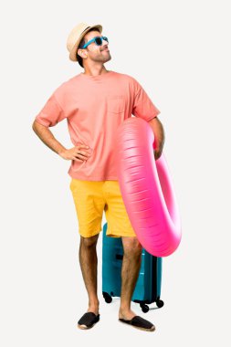 Onun yaz tatilinde şapka ve güneş gözlüğü ile Man Tam vücut kalça kolları ile poz ve izole arka plan üzerinde gülüyor