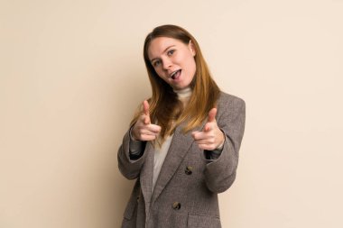 Genç iş kadını ön tarafı gösteriyor ve gülümsüyor.