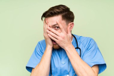 Cerrah doktor adam gözleri kaplayan ve parmaklardan bakarak