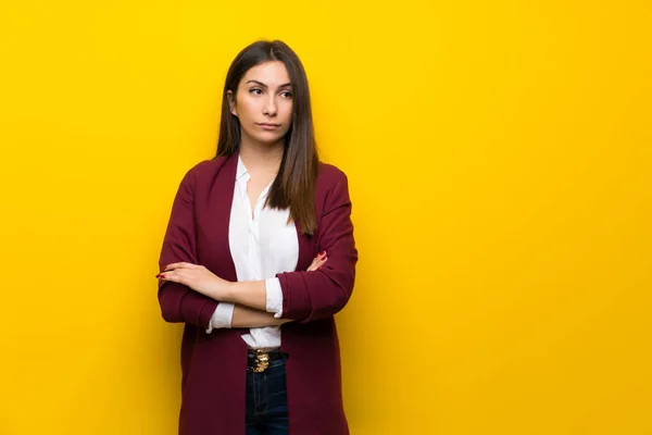 Young woman over yellow wall portrait