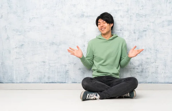 Asiatischer Mann Sitzt Lächelnd Auf Dem Boden — Stockfoto