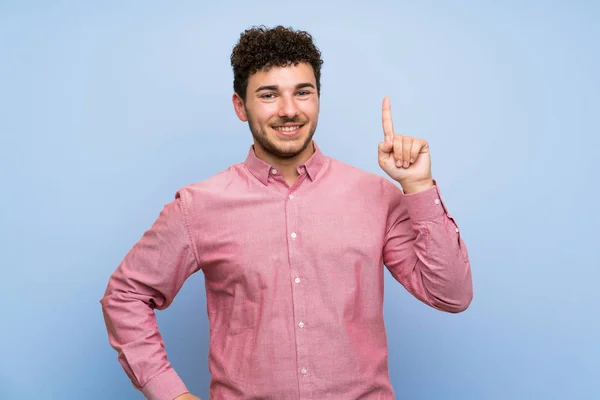 Man Curly Hair Isolated Blue Wall Showing Lifting Finger Sign — Stock Photo, Image