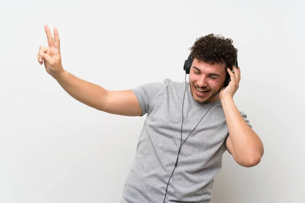 Man Met Krullend Haar Geïsoleerde Muur Luisteren Naar Muziek Met — Stockfoto