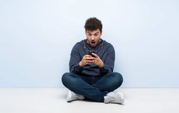 Young Man Sitting Floor Surprised Sending Message — Stock Photo, Image