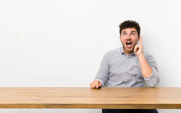 Jeune Homme Avec Une Table Pointant Vers Haut Surpris — Photo