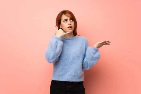 Jovem Ruiva Sobre Fundo Rosa Surpreendido Fazendo Gesto Telefone — Fotografia de Stock