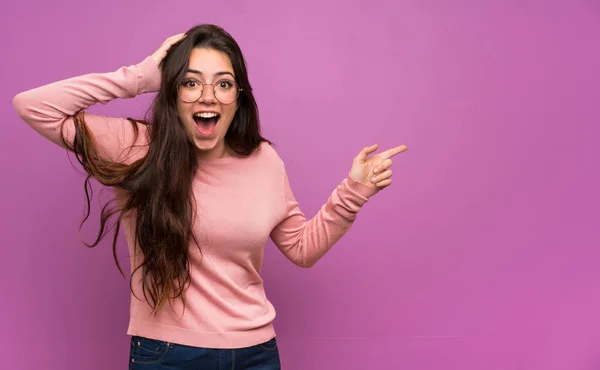 Adolescente Chica Sobre Pared Púrpura Sorprendido Señalando Dedo Lado — Foto de Stock