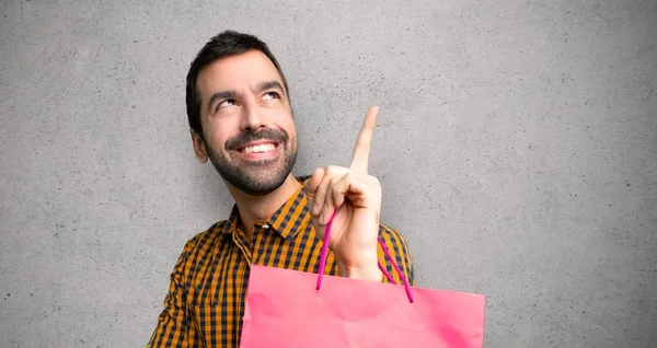 Hombre Con Bolsas Compras Apuntando Una Gran Idea Mirando Por —  Fotos de Stock