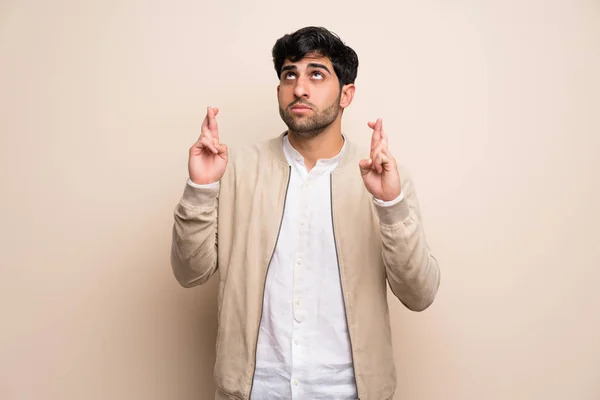 Young Man Isolated Wall Fingers Crossing Wishing Best — Stock Photo, Image