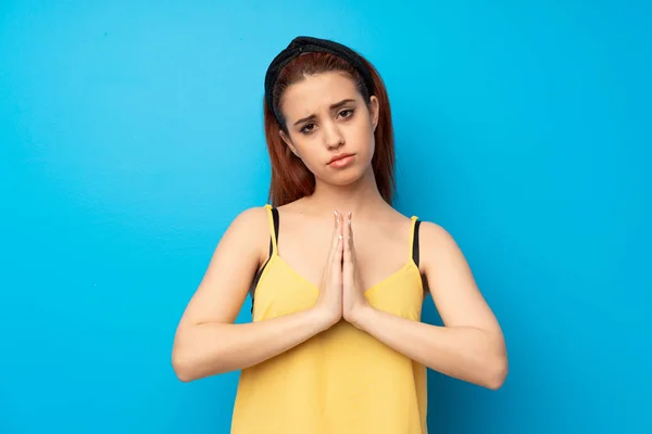 Jonge Roodharige Vrouw Met Blauwe Achtergrond Houdt Palm Bij Elkaar — Stockfoto