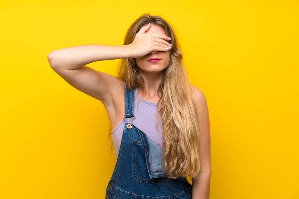 Mujer Rubia Joven Con Monos Sobre Fondo Amarillo Aislado Cubriendo — Foto de Stock