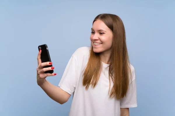 Junge Frau Über Blaue Wand Macht Ein Selfie — Stockfoto