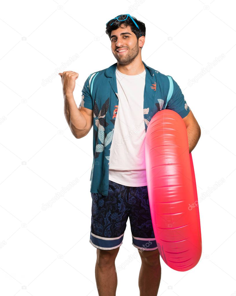 Man in trunks pointing to the side to present a product over isolated white background