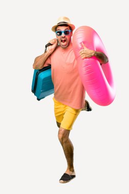 İzole arka planda hızlı çalışan onun yaz tatilinde şapka ve güneş gözlüğü ile Man Tam vücut