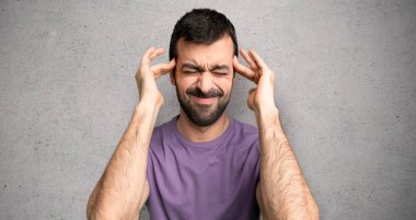 Yakışıklı adam mutsuz ve dokulu duvar üzerinde bir şey ile sinirli