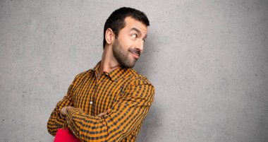 Dokulu duvar üzerinde bir gülümseme ile omuz üzerinden bakan alışveriş çantaları ile Adam