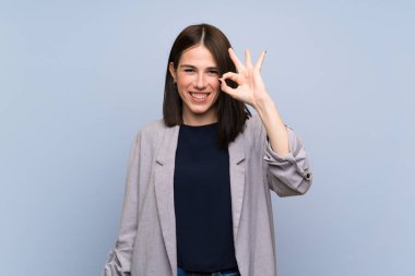 Genç kadın üzerinde izole mavi duvar gösteren ok işareti ile parmaklar