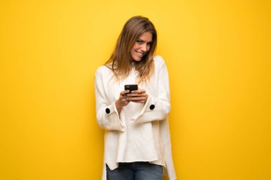 Sarışın kadın sarı duvar mobil ileti gönderme
