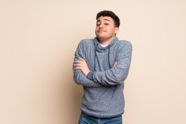 Omuzlarını kaldırırken şüpheyle hareket eden genç bir adam.