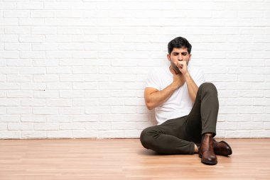 Katta oturan genç adam öksürük ile acı ve kötü hissediyor