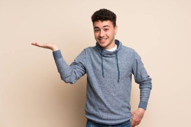 Genç adam boşaltmak hayali avuç içinde tutarak izole duvarın üzerinden bir reklam eklemek için