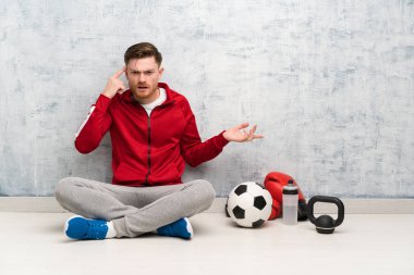 Kızıl saçlı spor adamı kafasına parmak koyarak delilik jest yapıyor