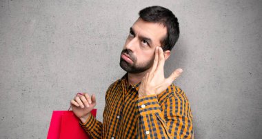 Dokulu duvar üzerinde intihar jesti yapma sorunları ile alışveriş çantaları ile Adam