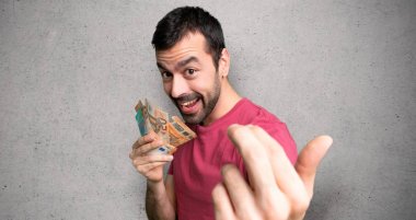 El ele gelmeye davet eden bir sürü para alan adam. Dokulu duvardan geldiğiniz için mutlusunuz.