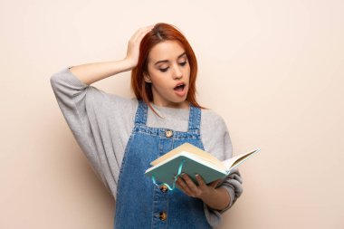 Genç kızıl saçlı kadın kitap okurken şaşırdı.
