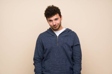 Üzgün ve depresif ifade ile izole duvar üzerinde kıvırcık saçlı Adam